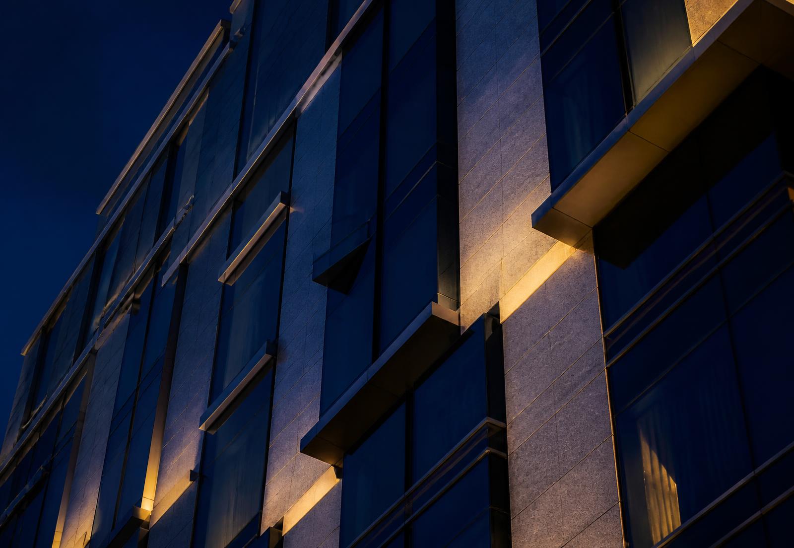 Detail of a modern stone and glass building facade at dusk